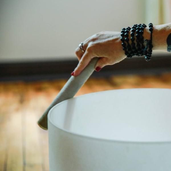 Woman playing crystal singing bowl